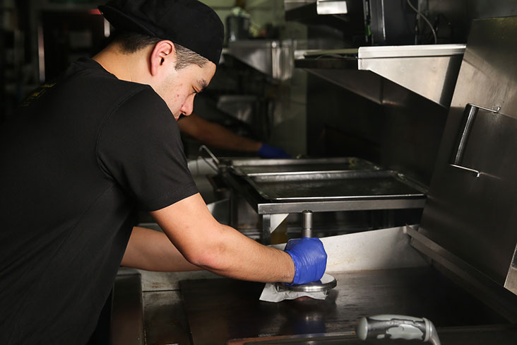 Once an order is placed, beef patties are smashed and cooked on a hot grill.