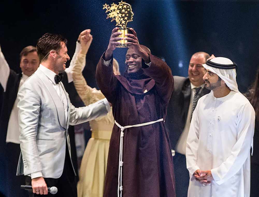 Kenyan teacher Peter Tabichi (centre) holding the Global Teacher Prize trophy presented by actor Hugh Jackman (left) as Dubai Crown Prince Hamdan bin Mohammed Al-Maktoum looks on in Dubai March 24, 2019. u00e2u20acu201d Handout pic via AFP