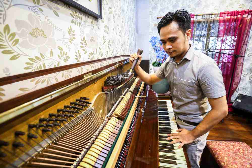 Mohammad Alif Yahya shows off the inside of the piano that belonged to the late Tan Sri P. Ramlee. u00e2u20acu201d Picture by Firdaus Latif