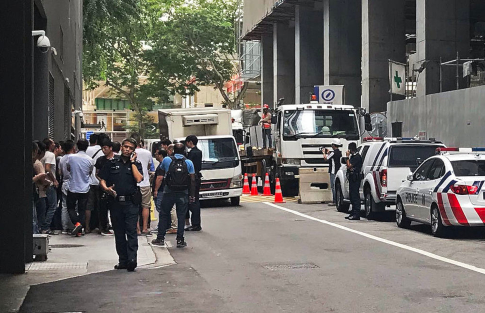 Police officers were seen talking to over 30 foreign workers at the site of the old Central Provident Fund building March 6, 2019. u00e2u20acu201d TODAY pic