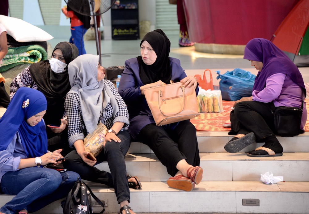 Khalidah Nazir Ahmad (centre) admitted she travelled by business class in 2014 but insisted it was because her brother transferred his mileage points to her. u00e2u20acu201d Picture by KE Ooi