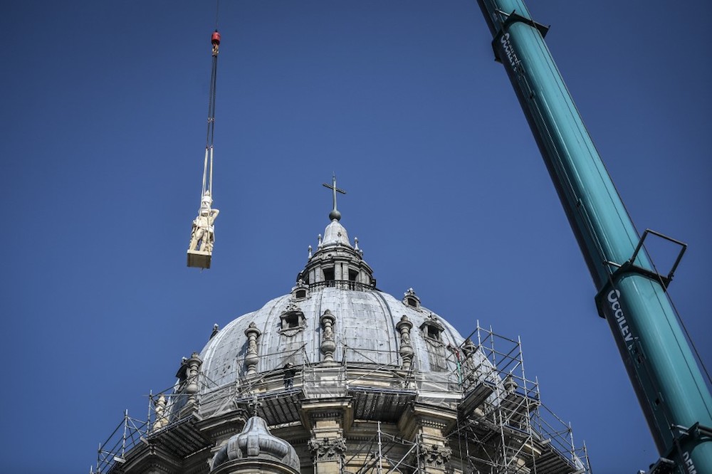 A crane lifts one of the restored genie and angel sculptures during their re-installation on the dome of the Notre-Dame du Val-de-Grace church in central Paris April 11, 2019. u00e2u20acu201d AFP pic