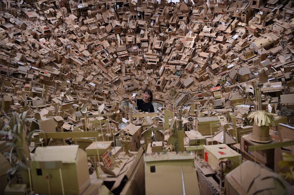 A visitor takes a selfie in the midst of an art work featuring houses made of cardboards on display at De La Salle university museum in Manila April 26, 2019. u00e2u20acu201d AFP pic