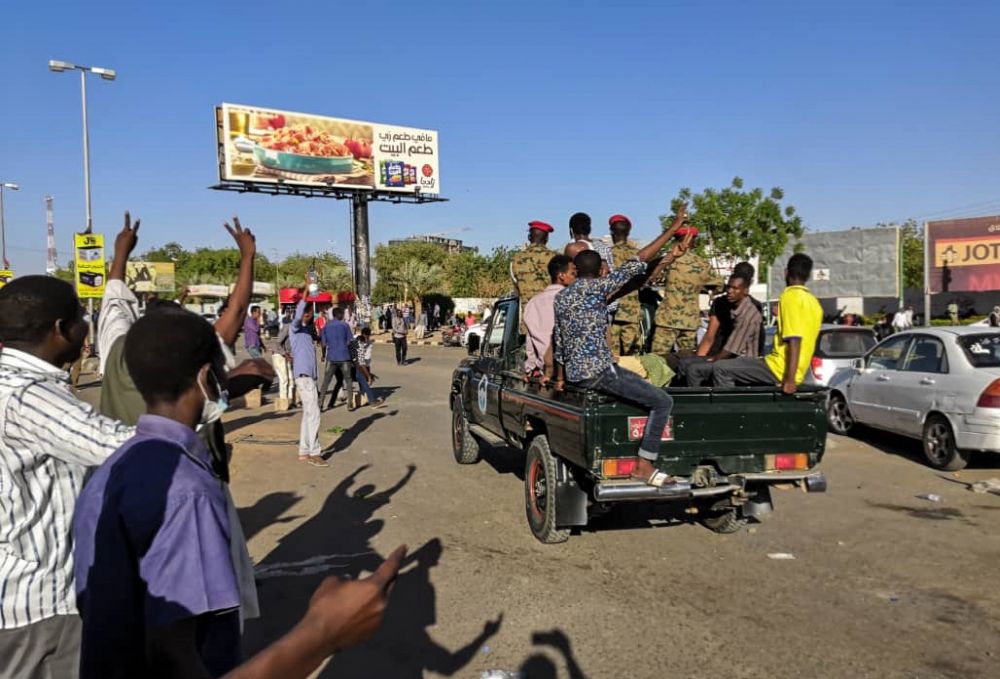 Sudanese protesters flash the victory after jumping on to the back of a military police vehicle near Khartoumu00e2u20acu2122s military headquarters April 6, 2019. u00e2u20acu201d AFP pic