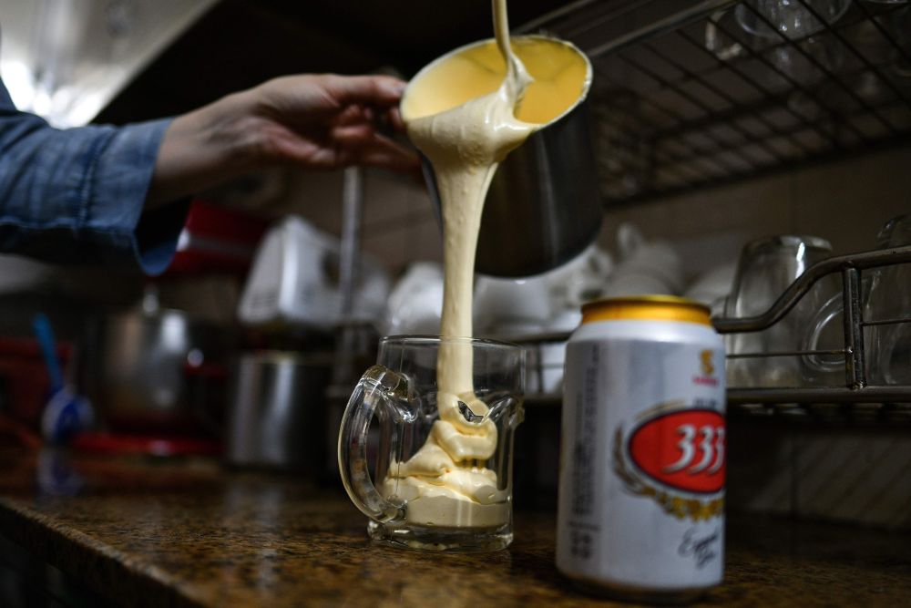 This picture taken April 4, 2019 at Giang Cafe in Hanoi shows Nguyen Giang pouring a sweetened egg mixture into a beer mug. — AFP pic