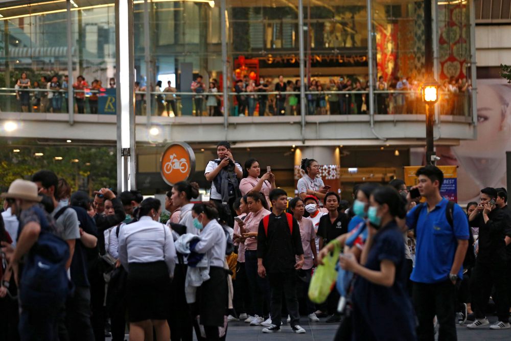People stand outside the Central World Complex after it was evacuated due to a fire, in Bangkok, Thailand, April 10, 2019. — Reuters pic