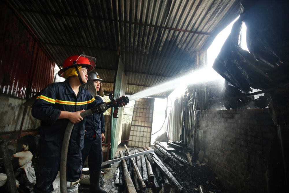 A firefighter uses a hose to douse a spot while battling a fire in a workshop complex in Hanoi April 12, 2019. u00e2u20acu201d AFP pic