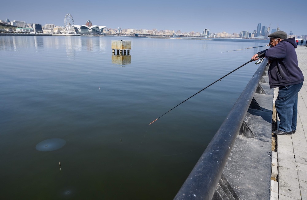 Men fish at an embankment of the Caspian Sea in Baku March 22, 2019. Seals, once a common sight on Baku's waterfront, have been declared endangered. u00e2u20acu201d AFP pic
