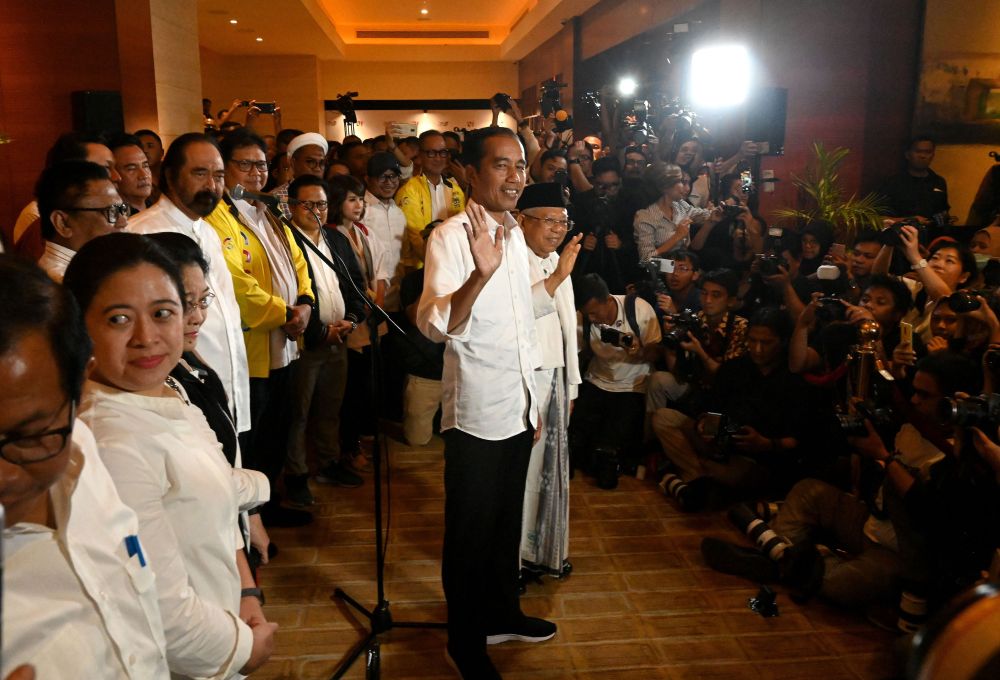Indonesian President Joko Widodo (centre) and his vice-presidential candidate Mau00e2u20acu2122ruf Amin (centre right) wave during a press conference after the countryu00e2u20acu2122s general election in Jakarta April 17, 2019. u00e2u20acu201d AFP pic