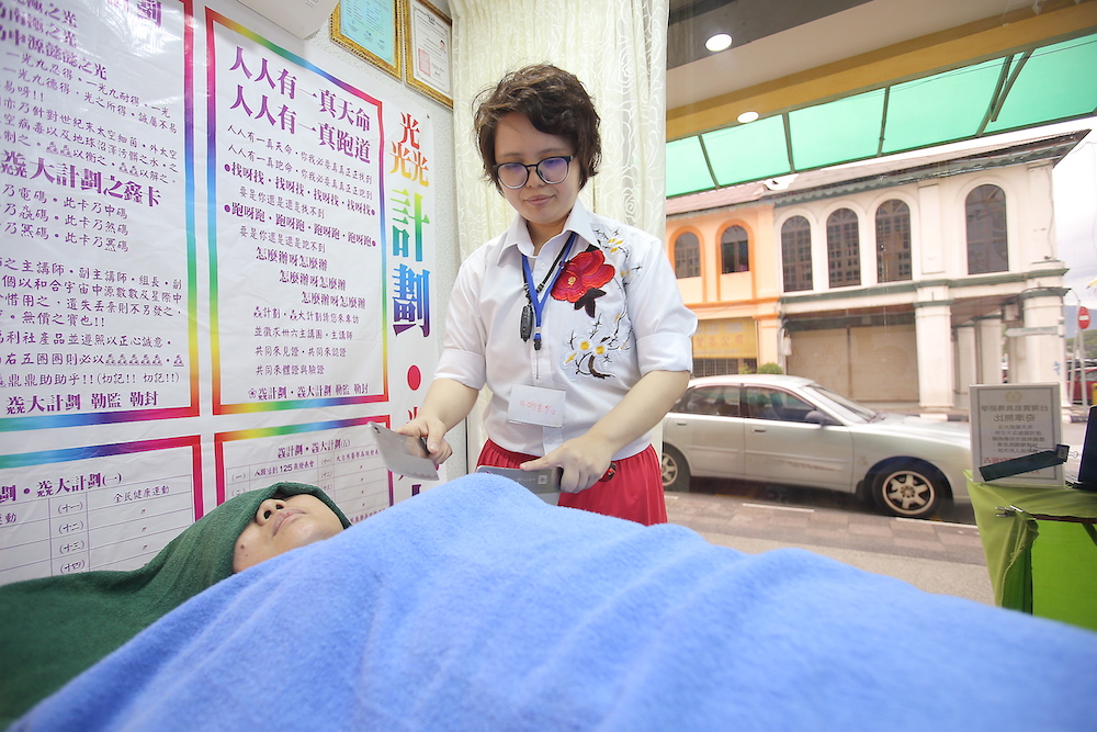 Wong Mun Yee massaging her customer using the knifes at her massage centre at Jalan Bandar Timah, Ipoh.  u00e2u20acu201d Picture by Farhan Najib