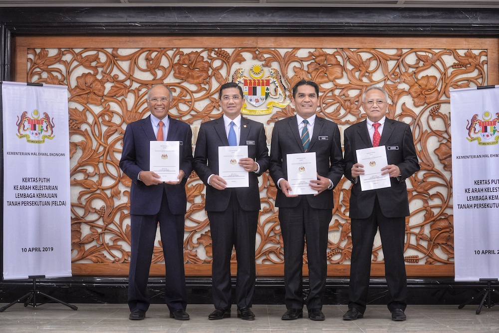 Tan Sri Megat Zaharuddin Megat Mohd Nor, Datuk Seri Azmin Ali, Mohd Radzi Md Jidin and Datuk Othman Omar pose with the Felda White Paper in Parliament April 10, 2019. u00e2u20acu201d Picture by Shafwan Zaidon