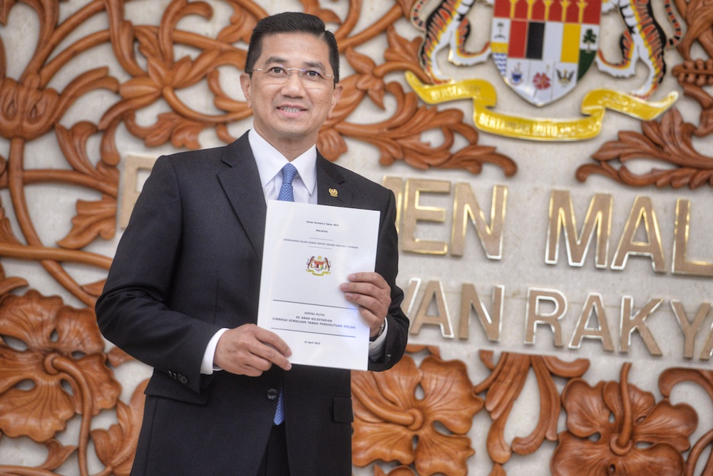 Economic Affairs Minister Datuk Seri Azmin Ali poses for pictures with the Felda White Paper in Parliament April 10, 2019. u00e2u20acu201d Picture by Shafwan Zaidon