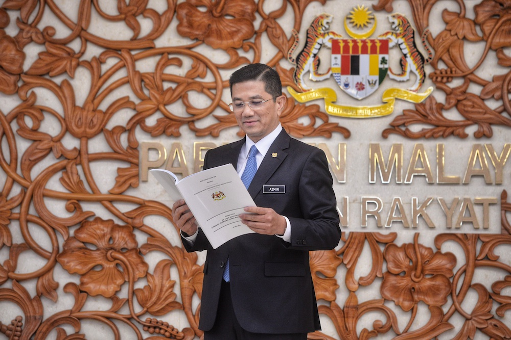 Economic Affairs Minister Datuk Seri Azmin Ali poses for pictures with the Felda White Paper in Parliament April 10, 2019. u00e2u20acu201d Picture by Shafwan Zaidon