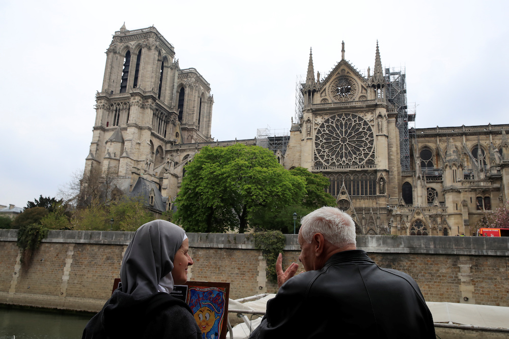 People stand in front of Notre-Dame Cathedral after a massive fire devastated large parts of the gothic gem in Paris April 16, 2019. u00e2u20acu201d Reuters pic