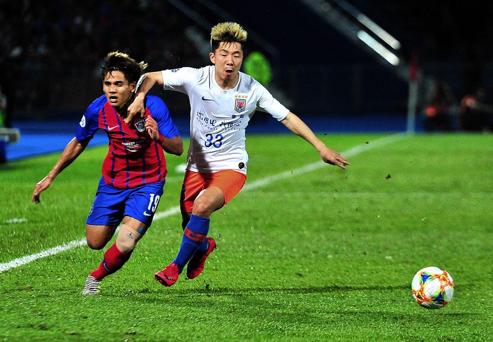 JDT player Muhammad Akhyar Rashid (left) in action with Shandong Luneng FC player Jin Jingdao during the Asian Champions League Group E competition in Johor Baru April 24, 2019. u00e2u20acu201d Bernama pic