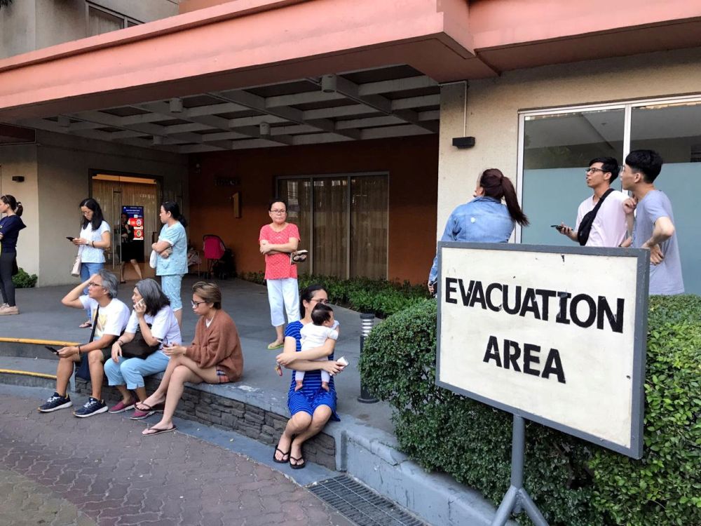 Residents sit outside after being evacuated from the condominium building after an earthquake in Makati City, Philippines, April 22, 2019. u00e2u20acu201d Reuters pic
