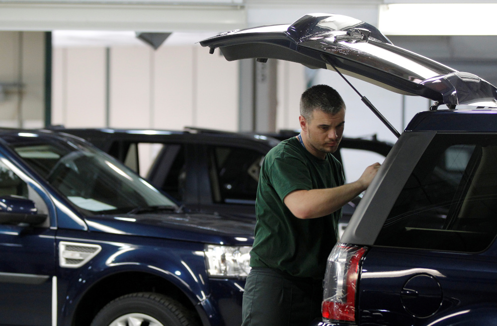 Workers examine Land Rover Freelander vehicles as they come off the production line at Jaguar Land Roveru00e2u20acu2122s Halewood assembly plant in Liverpool, northern England, March 2, 2011. u00e2u20acu201d Reuters pic