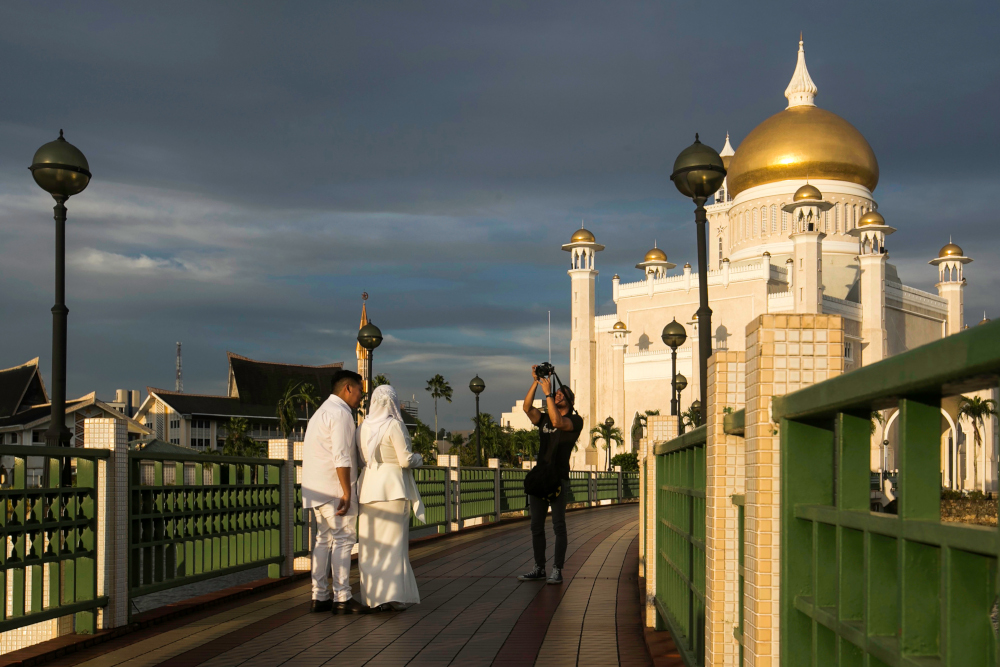 In this picture taken April 1, 2019 a newlywed couple has their photographs taken at the Sultan Omar Ali Saifuddien mosque in Bandar Seri Begawan. u00e2u20acu201d AFP pic