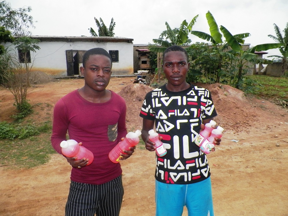 Men hold of samples of bottled liquid pepper ready for the market in Mbalmayo, Cameroon January 22, 2019. u00e2u20acu201d Thomson Reuters Foundation pic