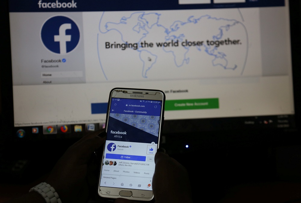 An illustration photo shows the Facebook page displayed on a mobile phone internet browser held in front of a computer screen at a cyber-cafe in downtown Nairobi, Kenya April 18, 2019. u00e2u20acu201d Reuters pic       