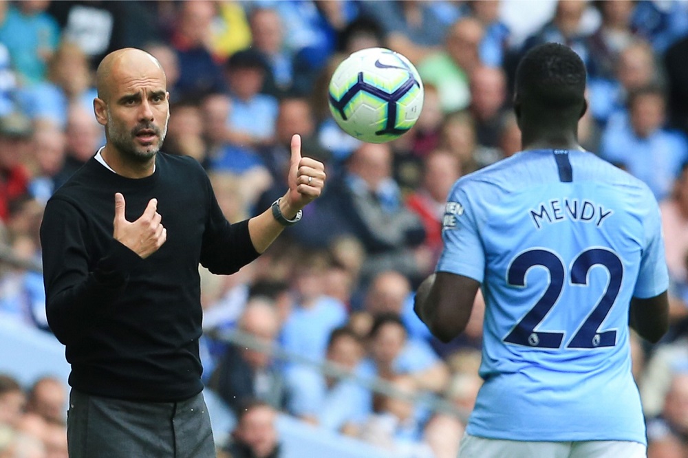 Manchester City's manager Pep Guardiola (left) throws the ball to Benjamin Mendy (right) during the football match between Manchester City and Huddersfield Town at the Etihad Stadium in Manchester August 19, 2018. u00e2u20acu201d AFP pic