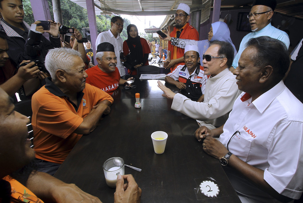 Datuk Seri Anwar Ibrahim and Pakatan Harapan candidate for Rantau Dr S. Streram chat with people over breakfast at Felda Sendayan in Seremban April 12, 2019. — Bernama pic
