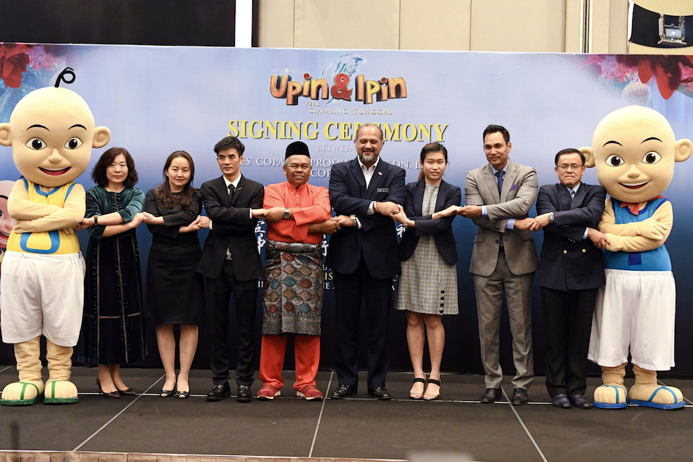 Gobind Singh Deo poses for pictures with Lesu00e2u20acu2122 Copaque Production Sdn Bhd managing director Burhanuddin Md Radzi, after an agreement signing ceremony with Cultural Investment Holding Co Ltd in Kuala Lumpur April 19, 2019. u00e2u20acu201d Bernama pic