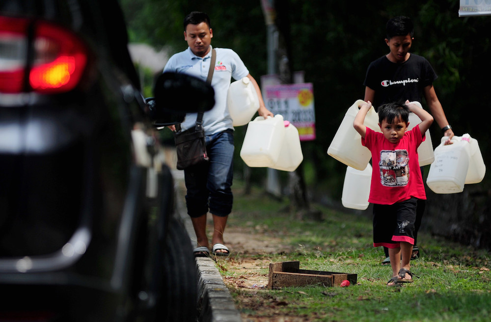 A boy carries plastic containers to a public water tap in Shah Alam April 24, 2019. u00e2u20acu201d Bernama pic