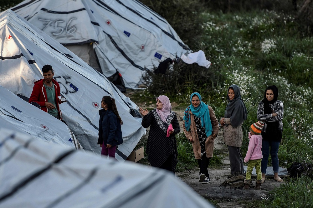 Women stand outside tents at an unofficial camp outside the refugee camp of Moria on the Greek island of Lesbos March 19, 2019. u00e2u20acu201d AFP pic  