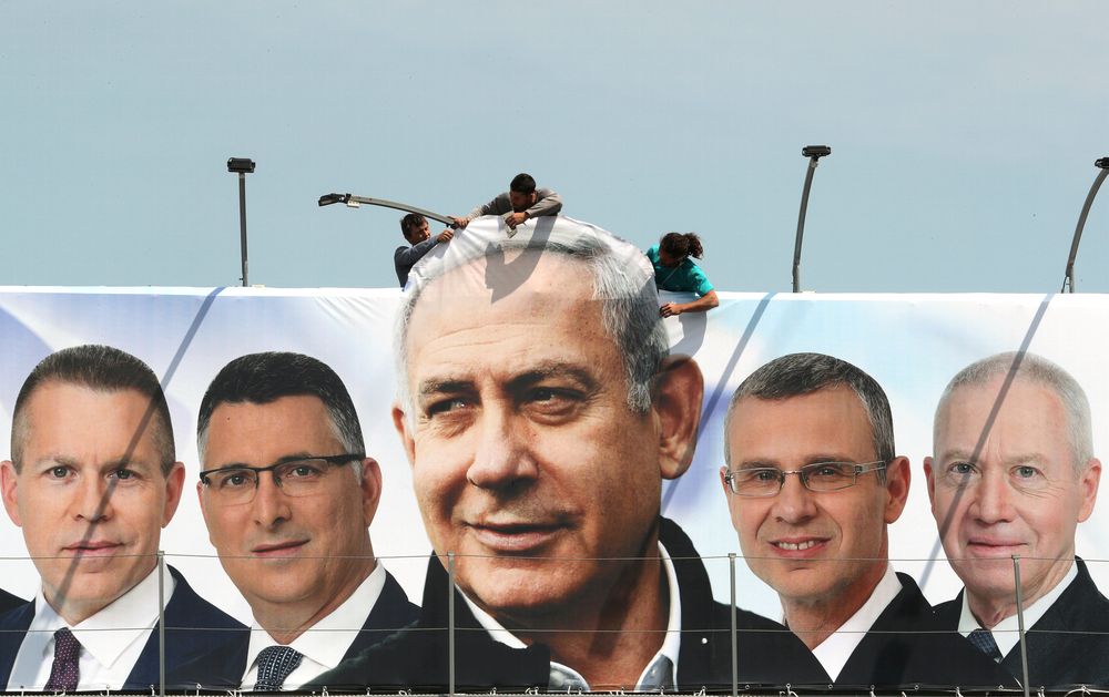 Labourers work on hanging up a Likud election campaign banner depicting Israeli Prime Minister Benjamin Netanyahu with his party candidates, in Jerusalem March 28, 2019. u00e2u20acu201d Reuters pic