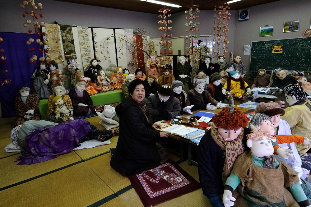 This picture taken on March 16, 2019, shows local resident Tsukimi Ayano posing with life-size dolls in her workshop at the tiny village of Nagoro in western Japan. — AFP pic