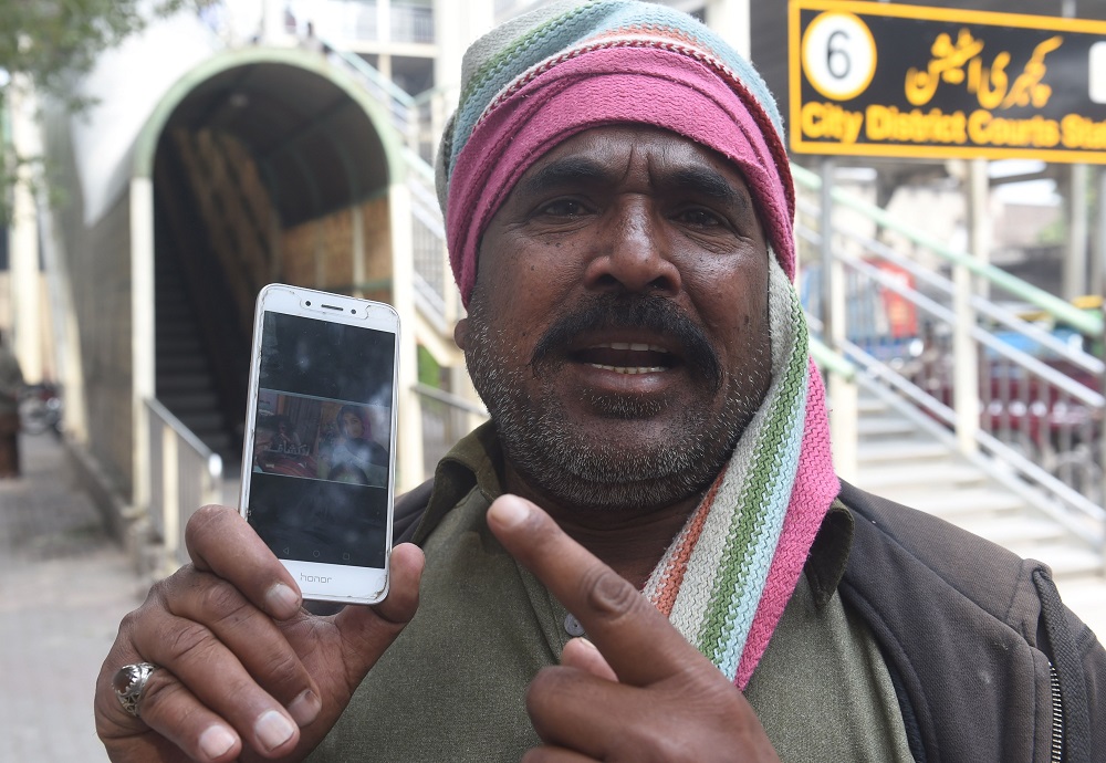 In this picture taken on March 14, 2019, Muhammad Riaz, father of 16-year-old Uzma, a maid who was found dumped in a city canal, shows her picture on a smartphone during an interview with AFP in Lahore. u00e2u20acu201d AFP pic  