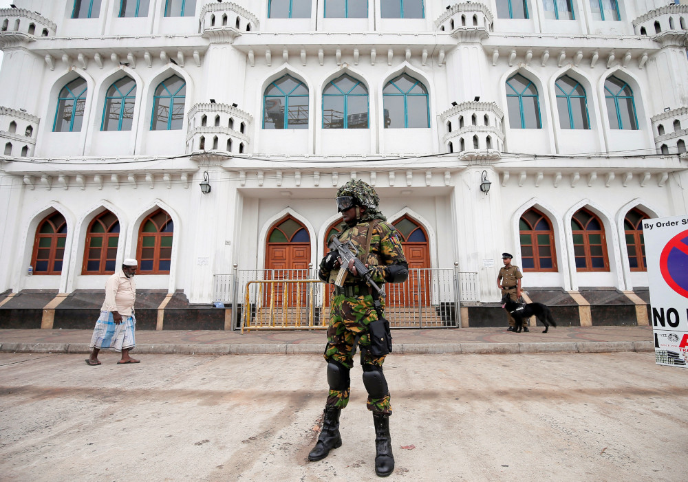Sri Lankan Special Task Force soldiers stand guard in front of a mosque as a Muslim man walks past him during Friday prayers at a mosque in Colombo, Sri Lanka April 26, 2019. u00e2u20acu201d Reuters pic