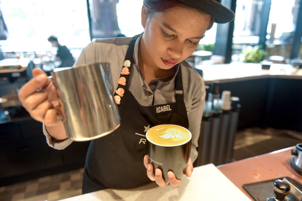 Isabel Russel pouring latte art in the shape of a swan. — Picture by Mukhriz Hazim   