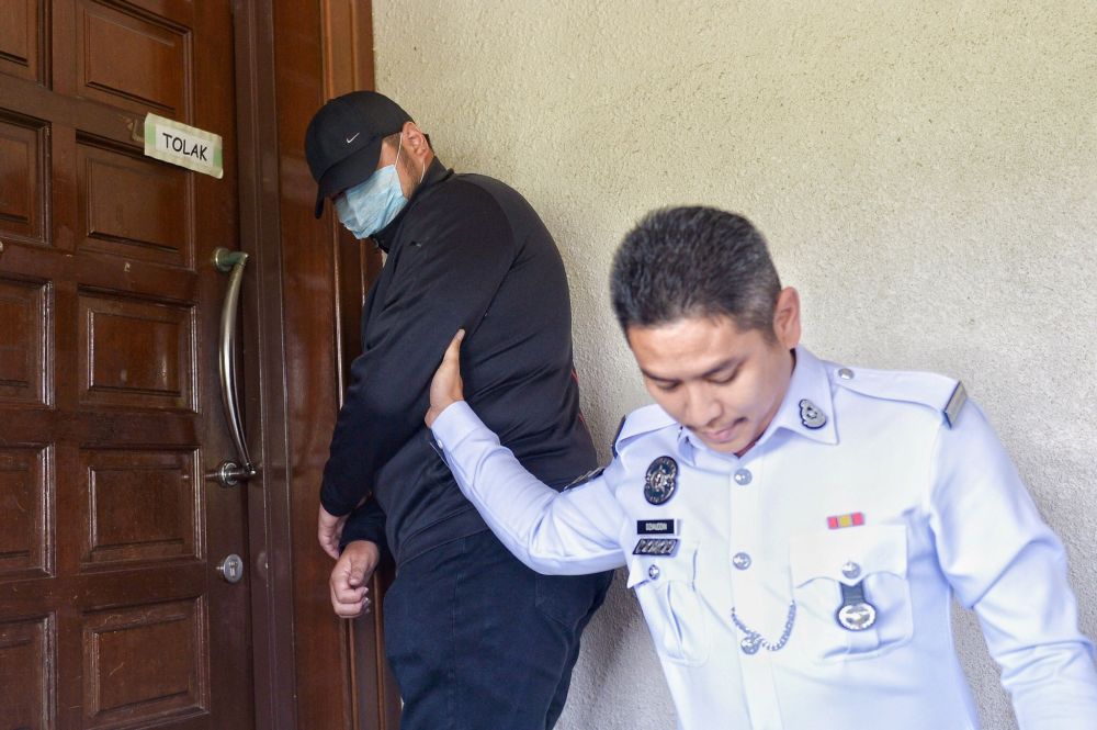 Tan Wooi Zhan, 25, is escorted by a police personnel at the Kuala Lumpur High Court April 4, 2019. u00e2u20acu201d Picture by Mukhriz Hazim