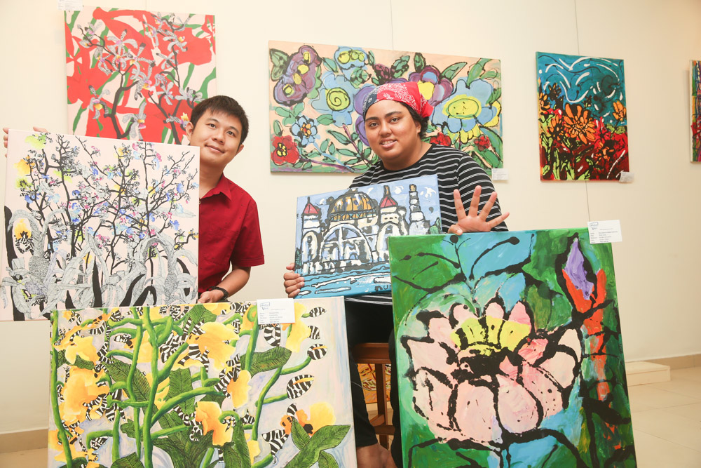 Clement Ooi (left) and Nurulakhmal Abdul Rahman pose with their paintings at the United Voice centre in Petaling Jaya. u00e2u20acu201d Picture by Choo Choy May