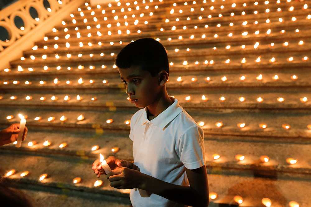 A boy holds a candle during a vigil in memory of the victims of a string of suicide bomb attacks across the island on Easter Sunday, at Lake House in Colombo April 28, 2019. u00e2u20acu201d Reuters pic