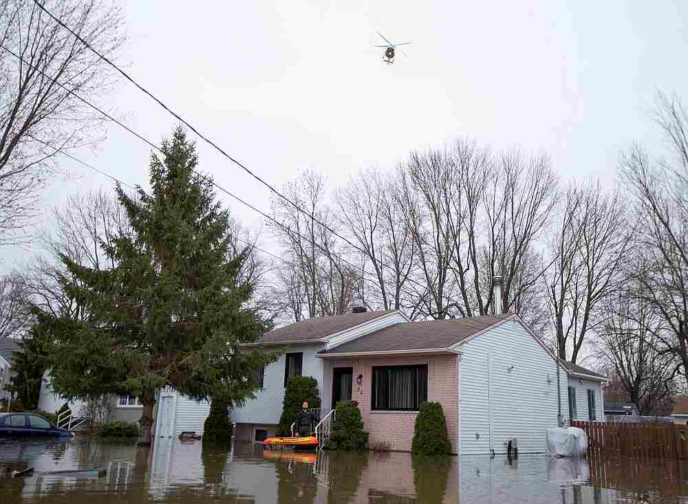 A police helicopter flies over a flooded street where residents return to pick up belongings after being evacuated in Sainte-Marthe-sur-le-Lac, Quebec, Canada April 28, 2019. u00e2u20acu201d Reuters pic
