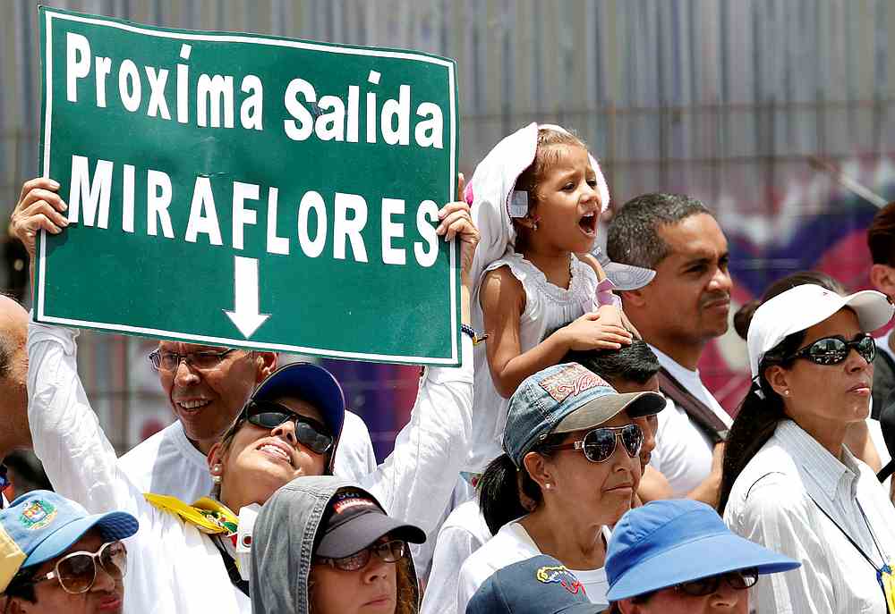A woman holds up a placard as Venezuelan opposition leader Juan Guaido holds a swearing-in ceremony for supporters in Caracas, Venezuela April 27, 2019. The placard reads 'Next exit Miraflores (Palace).' u00e2u20acu201d Reuters pic