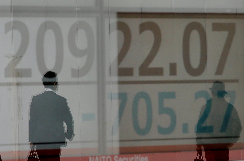 Men are reflected on an electronic board showing the Nikkei stock index outside a brokerage in Tokyo March 25, 2019. u00e2u20acu201d Reuters pic