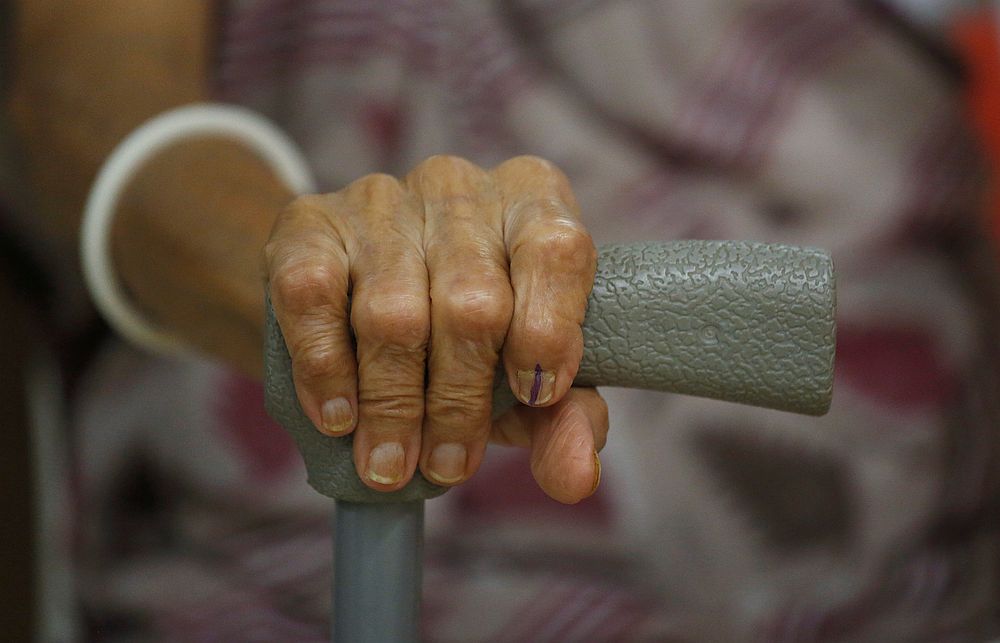 A woman holds a walking cane as her inked finger is seen after casting her vote at a polling station in Mumbai, India April 29, 2019. u00e2u20acu201d Reuters pic