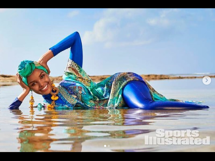 Sports Illustrated posted a picture of Halima posing in shallow water, wearing a turquoise hijab, long yellow earrings and a deep blue burkini. u00e2u20acu201d Picture via Instagram