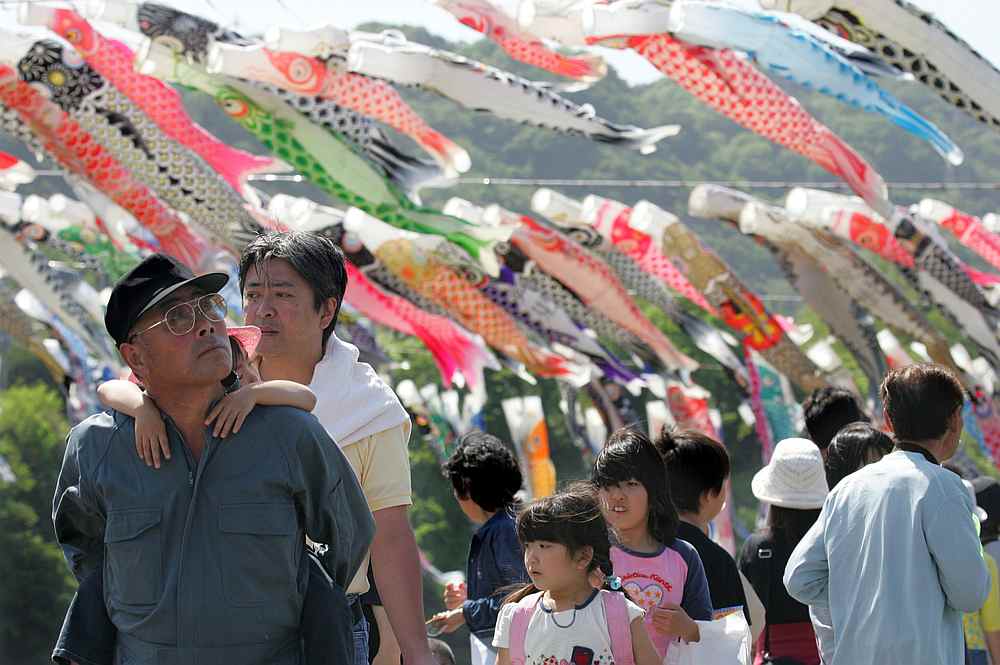 Holidaymakers view carp streamers hanging on the bank of the Sagami river in Sagamihara, southwest of Tokyo May 3, 2005. Millions of Japanese will be enjoying a 10-day holiday stretch from April 27 to May 6. u00e2u20acu201d Reuters pic