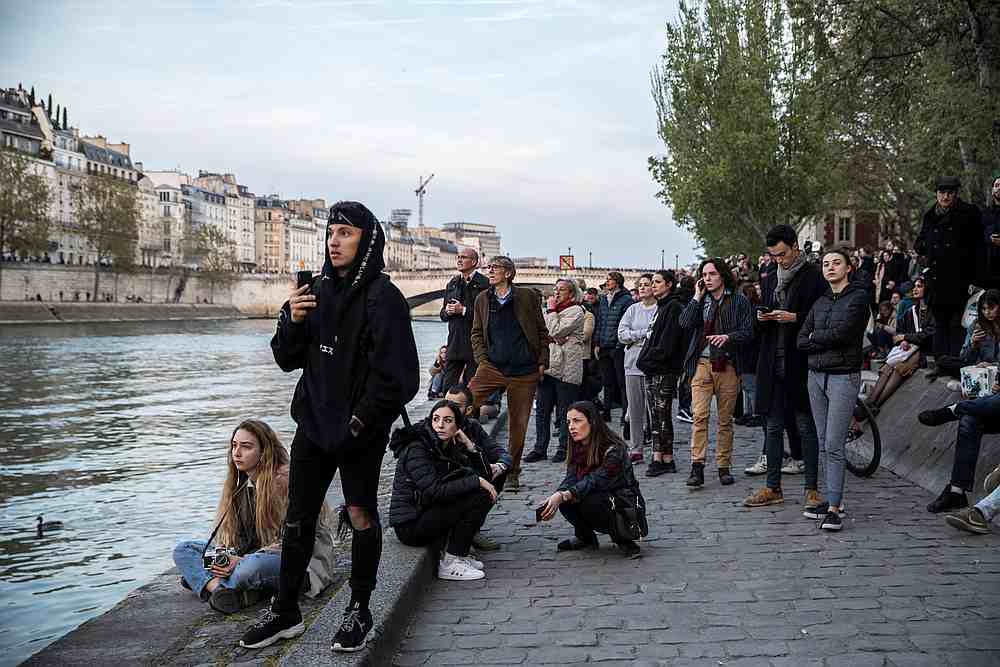 People watch as smoke and flames engulf the landmark Notre-Dame Cathedral in central Paris April 15, 2019. u00e2u20acu201d AFP pic
