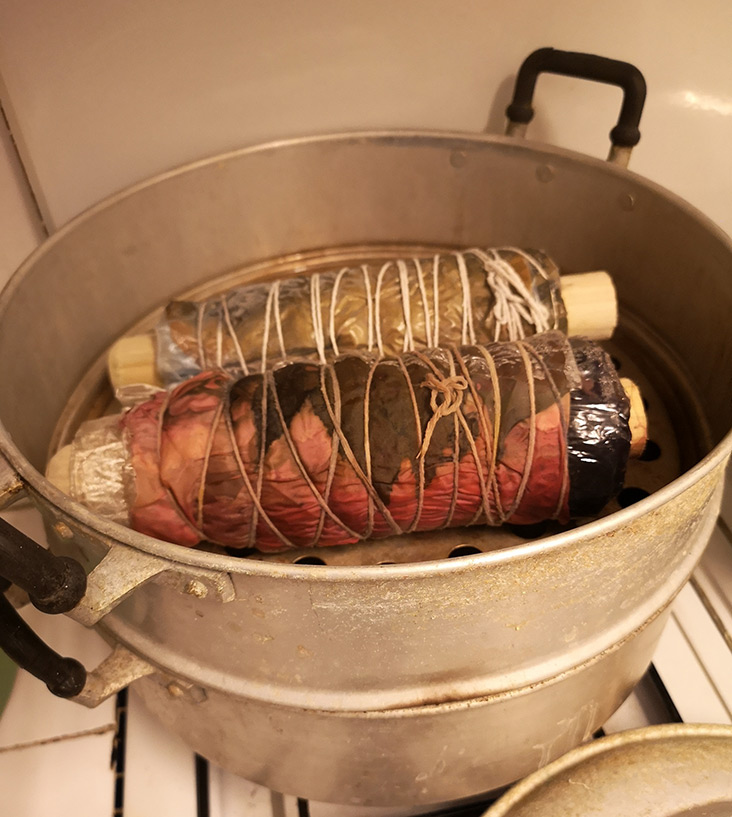 The leaves and flowers are placed on a natural dyed cloth, rolled up and steamed.