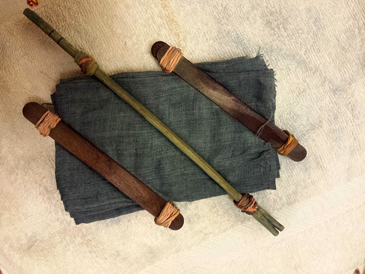 Various sticks are used to wrap the indigo dyed cloth to make 'shibori' patterns.
