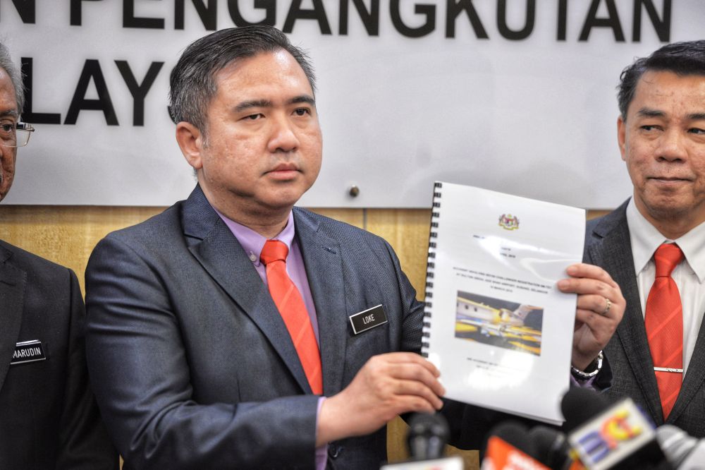 Transport Minister Anthony Loke holds up a copy of the report on the Subang Airport runway accident during a press conference in Putrajaya April 19, 2019. u00e2u20acu201d Picture by Shafwan Zaidon