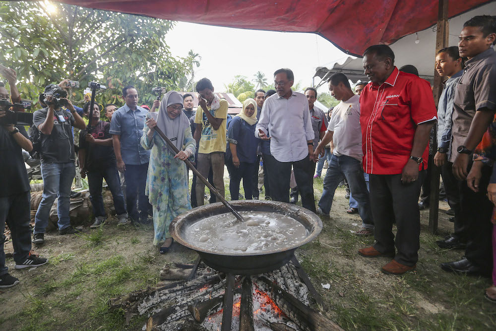 Datuk Seri Dr Wan Azizah Wan Ismail stirs dodol as Pakatan Harapan candidate for the Rantau by-election Dr S. Streram and Datuk Seri Anwar Ibrahim look on at Kampung Pasir in Kuala Sawah April 11, 2019. u00e2u20acu201d Picture by Yusof Mat Isa