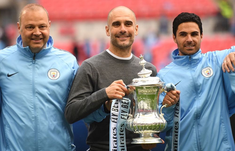 Manchester Cityu00e2u20acu2122s manager Pep Guardiola (centre) holds the winner's trophy as the team celebrates victory after the English FA Cup final match between Manchester City and Watford at Wembley Stadium in London, May 18, 2019. u00e2u20acu201d AFP pic
