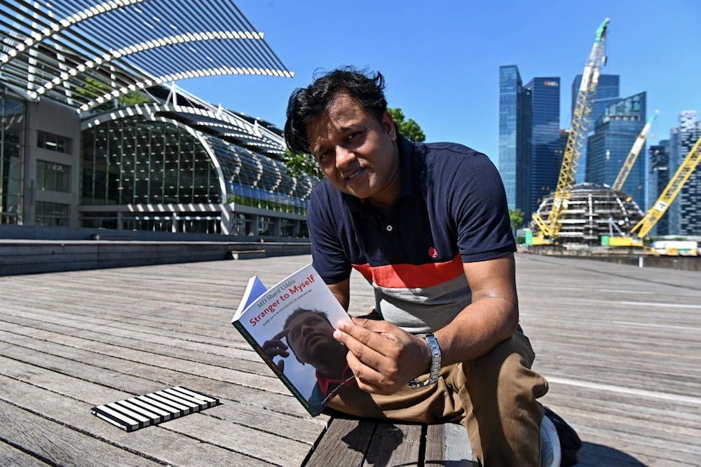 Bangladeshi migrant worker MD Sharif Uddin poses for a photograph while holding his book in Singapore April 15, 2019. u00e2u20acu201d AFP pic